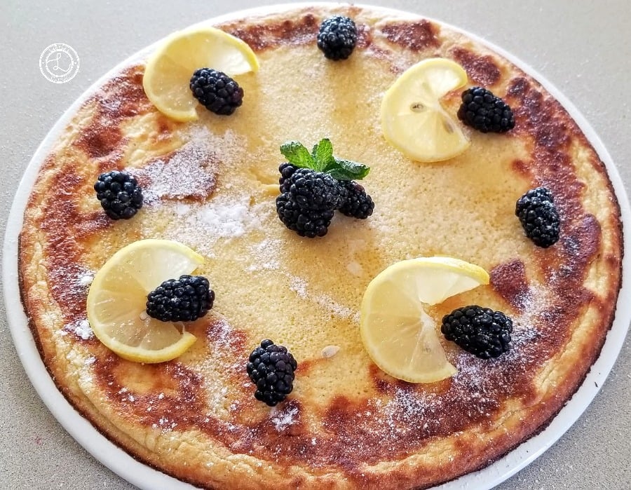 Gluten-Free Dutch Pancake Dutch Pancake on a large plate with lemon slices, blackberries, and mint