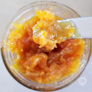 Orange Marmalade jar with a little bit on a butter knife
