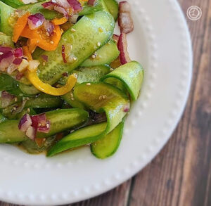 Asian Cucumber Salad on a white plate with homemade ginger dressing
