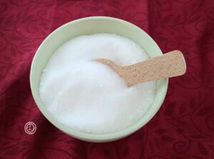 Monkfruit Sweetener in a bowl with a wooden spoon sticking out of it.