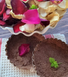 A picture of two tart shells with rose petals.