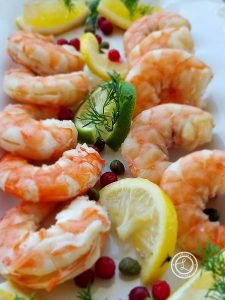 Scandinavian Dill Shrimp on a plate with lime and lemons