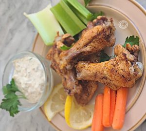 3 chicken wings on a plate with carrots, celery, and homemade dairy-free ranch dip