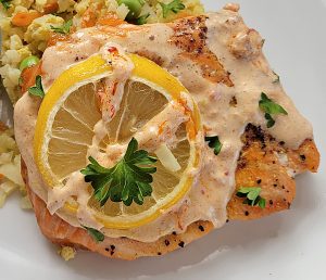 Keto Curry Salmon with lemon and masala sauce on top of a bed of fried Cauliflower Masala Rice.