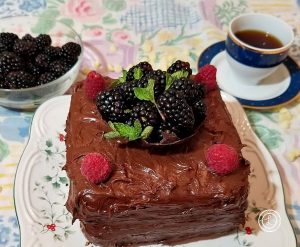 Cake with blackberries and a cup of coffee