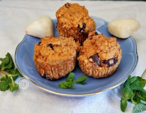 3 muffins on a blue plate with 2 white chocolate hears and sprigs of mint