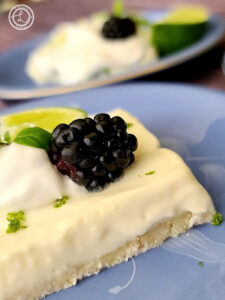 A side view of Key Lime Cheesecake with a piece behind it.