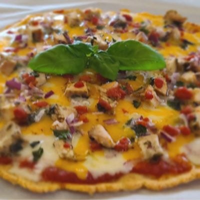 Cooked pizza with a sprig of basil to decorate