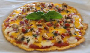 Cooked pizza with a sprig of basil to decorate
