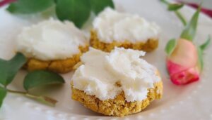 A close up of 3 frosted Pumpkin Cookies