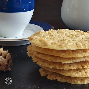 A side view of a stack of Gluten-Free Swedish Oatmeal Wafers and part of a coffee cup.
