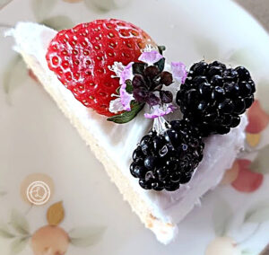A slice of cake with frosting and fruit