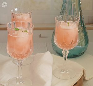 Three glasses of Homemade Strawberry Rhubarb Slush with a vase in the background.