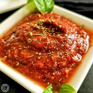 Homemade Quick and Easy Marinara a bowl of marinara with sprigs of basil on two corners.