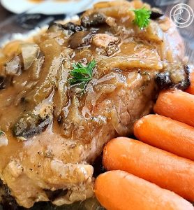 A close up of the Smothered Onion Mushroom Pork Chops with carrots.