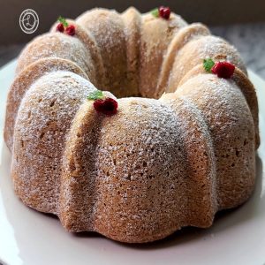 Gluten-Free Swedish Spice Cake (a Bundt cake) topped with sprig of mint and lingonberries.