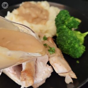 Turkey gravy being poured onto some turkey