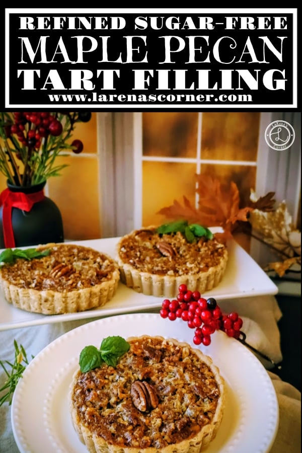 Maple Pecan Tart Filling Recipe Maple Pecan Tart Filling. A plate with a tart on it. A platter with two tarts in the background, in front of a window with flowers in a vase and leaves.