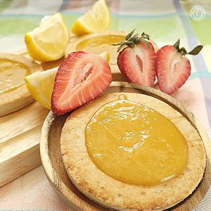 Gluten-Free Lemon Pie Cookies and strawberry wedges in the background.
