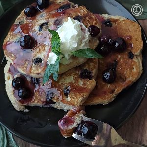 A close-up of sauce on blueberry pancakes.