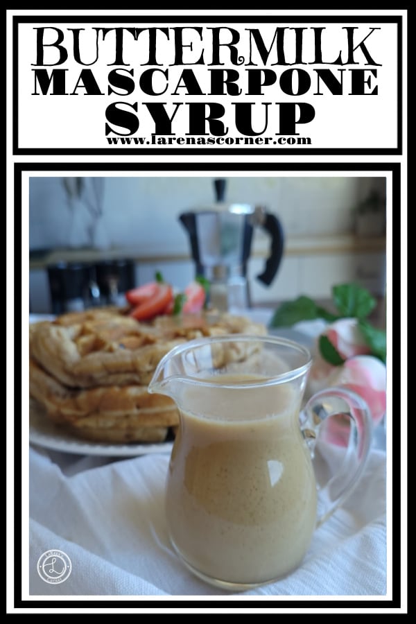 Mascarpone Syrup in a small pitcher in front of a stack of waffles with an espresso maker and flowers in the background.