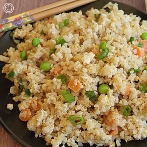 A plate of Egg Fried Cauliflower Rice with chopsticks in the corner.