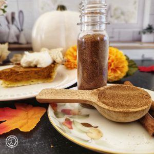 Homemade Pumpkin Pie Spice Recipe. Square photo. Spice in front of a piece of pie and small white pumpkin.