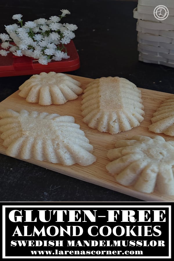 Gluten-Free Almond (Tartlets) Cookies. Several cookies on a small cutting board. with flowers in the background. 