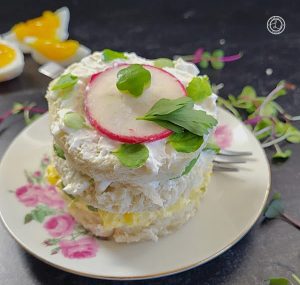 A Gluten-Free Mini Sandwich Cake off center with boiled eggs in the background.