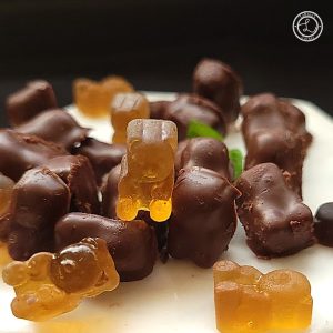 Chocolate Gummy Bears mixed in with Gummy Bears on a plate.