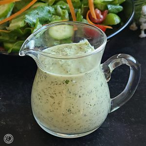 A close up of Green Goddess Dressing in a small pitcher