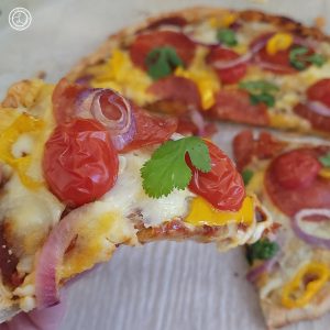 Gluten-Free Yeast Pizza Dough topped with sauce, cheese, meat, tomatoes, and cilantro.