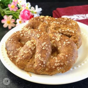 Gluten-Free Soft Pretzels on a plate with flowers and a red napkin in the background.
