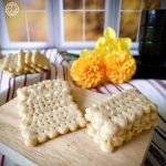 Gluten-Free Club Crackers. Crackers in stacks on a cutting board in front of a window with flowers.