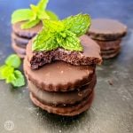 Gluten-Free Thin Mint Cookies a square photo of three stacks of cookies with thress sprigs of mint.